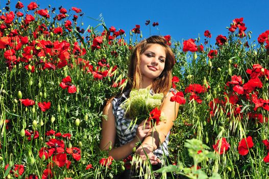 beautiful girl with long hair relaxing in the poppy field 