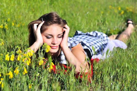 beautiful teen girl laying on the spring meadow 