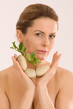 young woman with an aromatherapy with herbs and stones