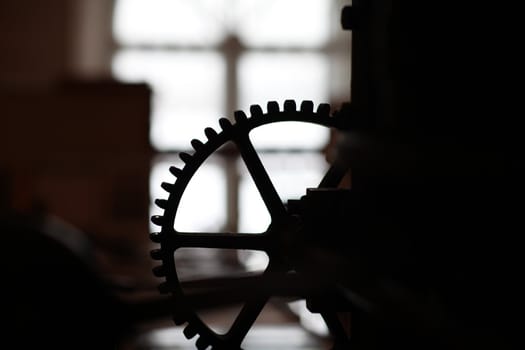 The mechanism of gear wheels, fragment of an antique printing press, close-up