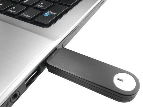 Isolated black USB flash drive in a gray laptop