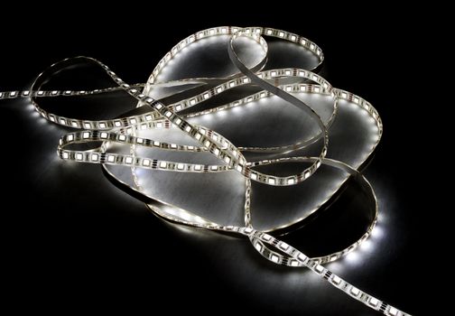 white led strip with a glue layer, background in the dark, illuminated by strip