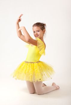 Cute little ballerina exercising, studio shot on white background 