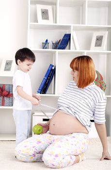 portrait of a pregnant woman and her son, at home