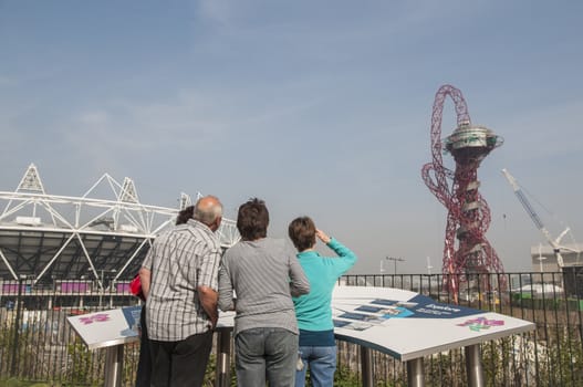 LONDON, UK – MARCH 24: Visitors looking at Olympic Stadium and Anish Kapoor sculpture in the background on March 24, 2012 in London. The Olympic Park is due to be ready in summer.