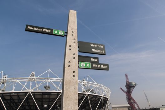 LONDON, UK – MARCH 24: Details of sign post with Olympic stadium in the background on March 24, 2012 in London. All locations around the Olympic Park are undergoing redevelopment works.