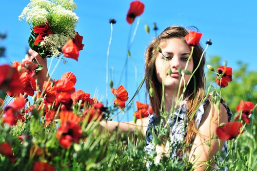 photo of teen girl through the grass on the poppy field 