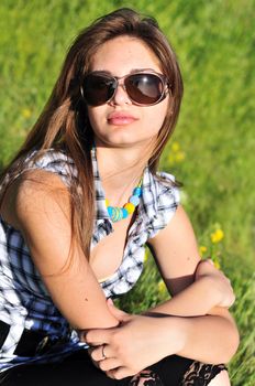 fashion beautiful  girl wearing sunglasses sitting outdoors
