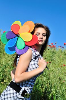 girl and windmill sitting in the grass over the blue sky