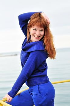cheerful redheaded girl near the sea in spring time