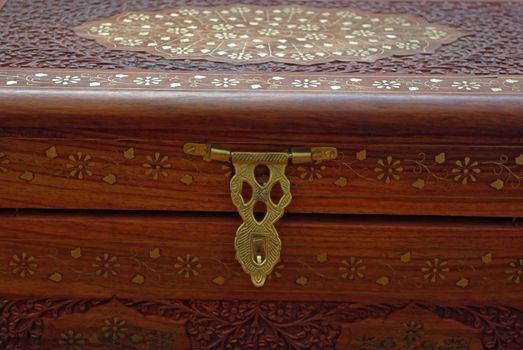 Engraved wooden chest  with metallic inlay ornament.