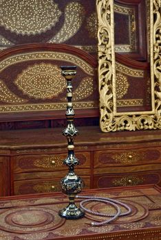 Hookah on a engaved table in a beautiful wooden room