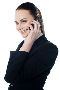 Female executive talking on mobile and smiling at camera