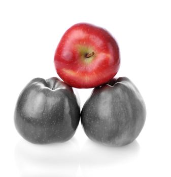 Pyramid with one different red apples and two colourless apples on white background
