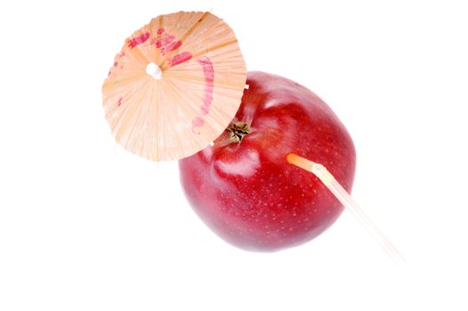 Red fresh apple with cocktail tube and ambrella