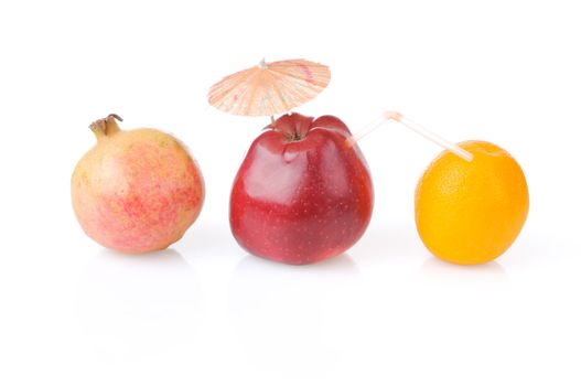 Red apple with umbrella and tube, one pomegranate and orange