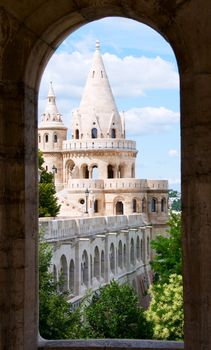 Fairytale looking Budda castle towers through  round-headed window of a tower