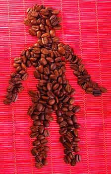 Heap of roasted coffee beans placed on bamboo man in shape of man figure