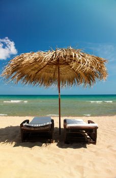 Two canvas chairs and umbrella on beautiful tropical beach