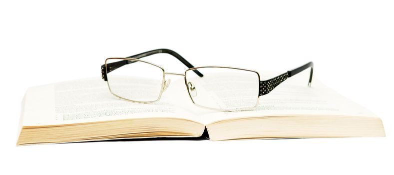Glasses with book on white background