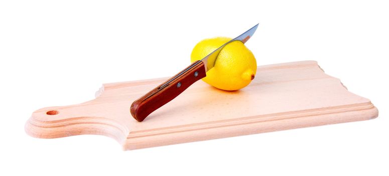 Knife pierces a  lemon on wooden plank. Isolated on white background.