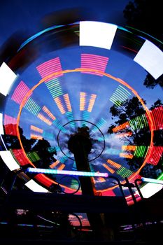 Ferris wheel in amusement park, blurred lights, night view 