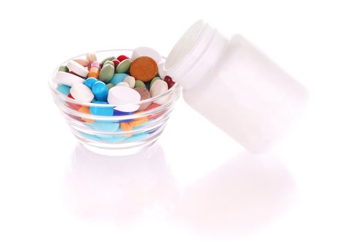 Transparent saucer and white bottle with many-colored pills