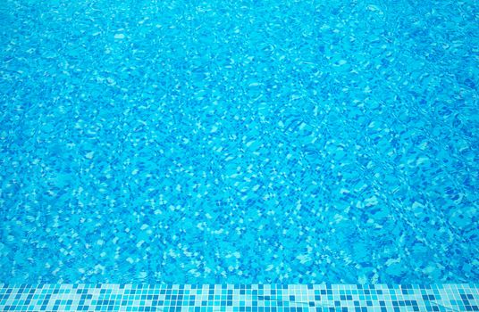 Part of swimming pool with blue clear water 