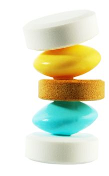 Column with five pills stand on each other on white background