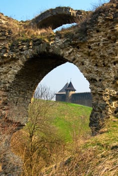 Two towers of ancient castle through old arch