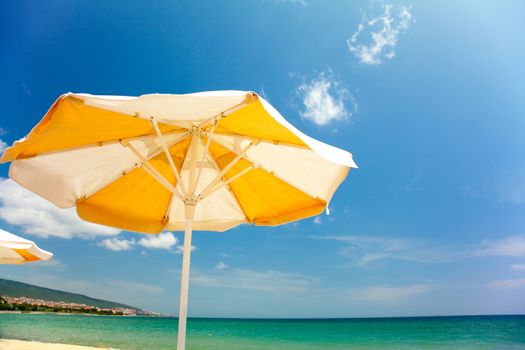 Orange umbrella on beautiful tropic beach 