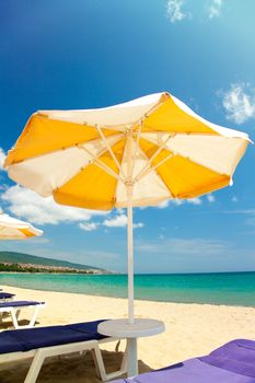 Bright umbrellas and chairs on beautiful tropical beach 