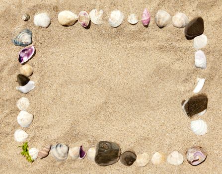 Sea shells and stones frame on white sand 