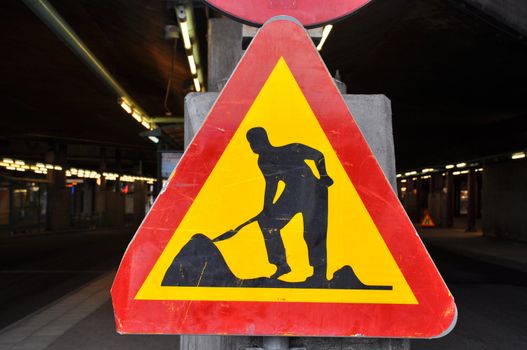 Well used roadwork traffic sign in red and yellow.