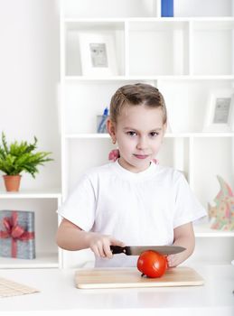 beautiful girl in the kitchen cooking vegetables