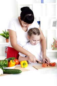 Mother and daughter cooking vegetable salad together