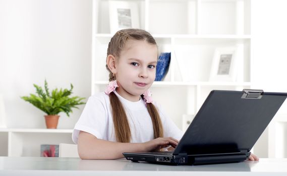 girl working on laptop at home, sitting at the table