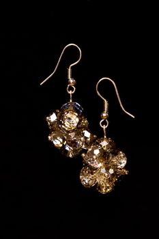 Shining elegant modern earrings with zircons isolated on black