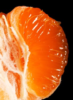 Juicy ripe mandarin segment on black background