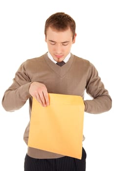 Young business man opens a yellow post package with interest. Isolated on white.