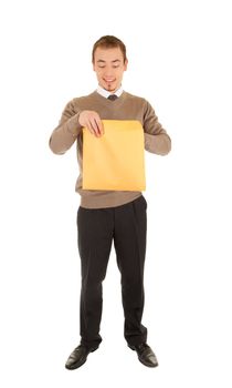 Young business man opens a yellow post package with interest. Isolated on white.