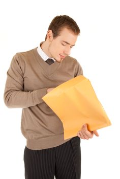 Young business man opens a yellow post package with interest. Isolated on white.