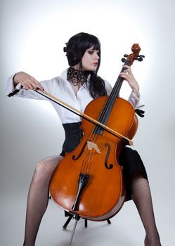 Romantic girl playing cello, studio shot over white background 