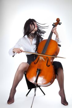 Sensual girl playing cello and moving her hair, studio shot 