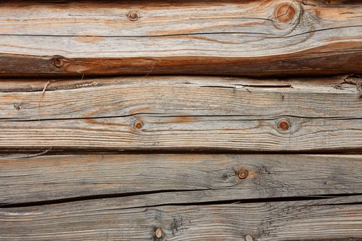 Old horizontal wooden logs. Part of ancient wooden house walls