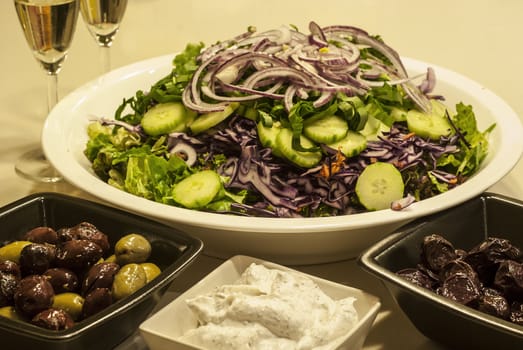 Salad dish, olives, caviar,white wine glasses