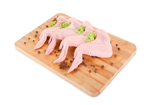 Raw chicken wings on chopping board, isolated on white background, clipping path included 