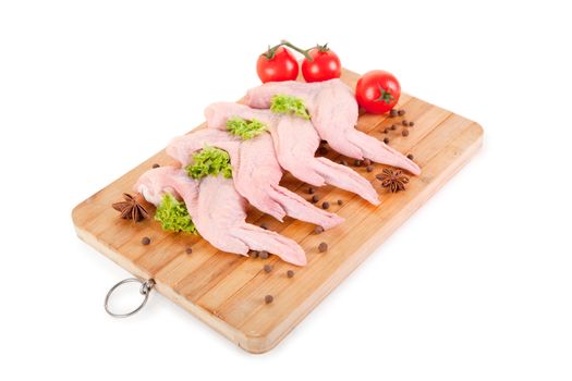 Raw chicken wings with red tomatoes, clipping path included 