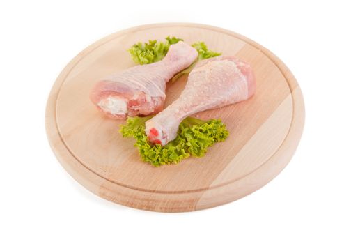 Fresh raw chicken legs on wooden board, clipping path included 