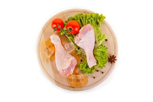 Fresh and frozen chicken legs with vegetables, isolated on white background, with clipping path 